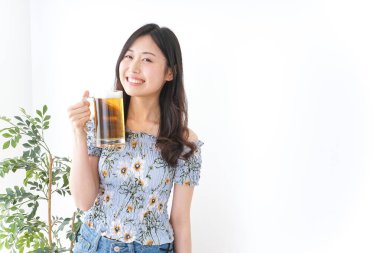 Bira bahçesinde bira içen genç bir kadın.