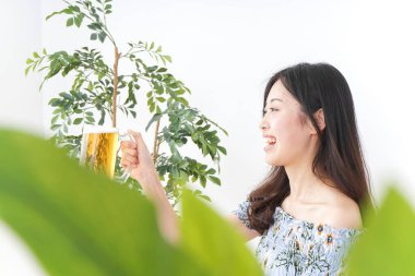 Bira bahçesinde bira içen genç bir kadın.