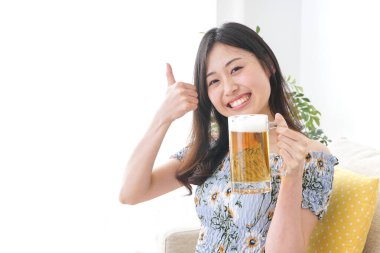 Evde alkol alan genç bir kadın.