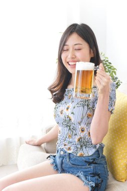 Evde alkol alan genç bir kadın.