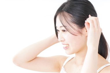 Genç bir kadın saçını bağlıyor.