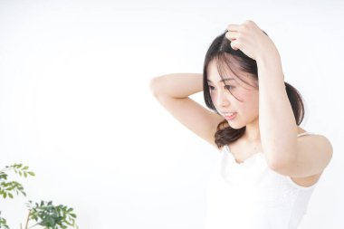 Genç bir kadın saçını bağlıyor.