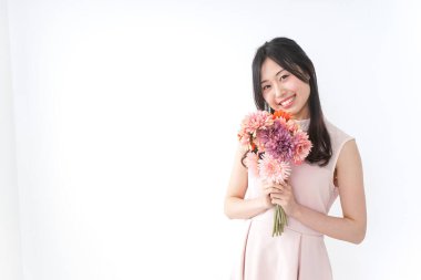 Çiçek buketi olan genç bir kadın.