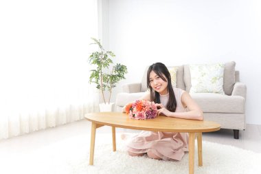 Çiçek buketi olan genç bir kadın.