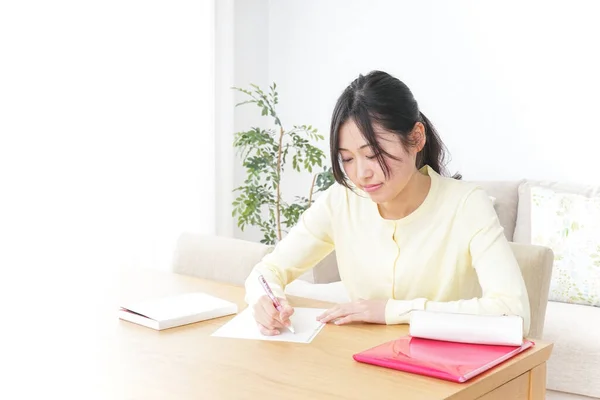 Female student studying for an entrance exam at home