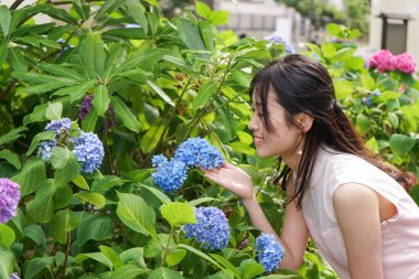 Çiçeklerin yanında poz veren genç kadın