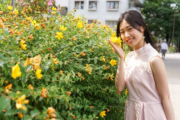 Çiçeklere Bakan Genç Bir Kadın — Stok fotoğraf
