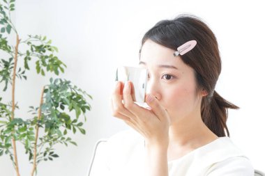 Genç Asyalı kadın makyaj yapıyor.