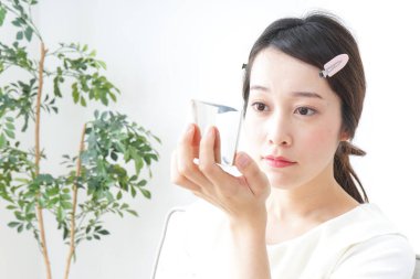 Genç Asyalı kadın makyaj yapıyor.