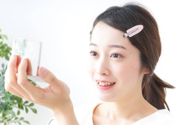 Genç Asyalı kadın makyaj yapıyor.