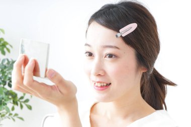 Genç Asyalı kadın makyaj yapıyor.