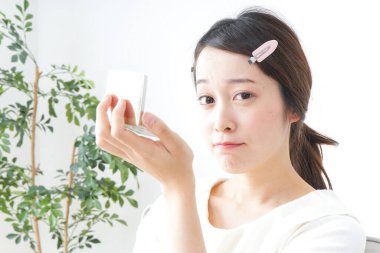 Genç Asyalı kadın makyaj yapıyor.