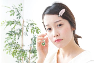 Genç Asyalı kadın makyaj yapıyor.