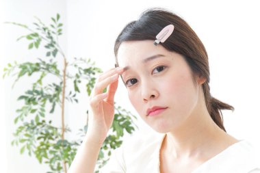 Genç Asyalı kadın makyaj yapıyor.