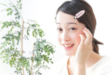 Genç Asyalı kadın makyaj yapıyor.