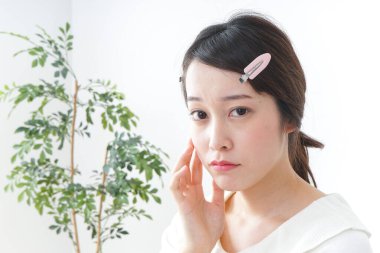 Genç Asyalı kadın makyaj yapıyor.