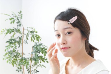 Genç Asyalı kadın makyaj yapıyor.