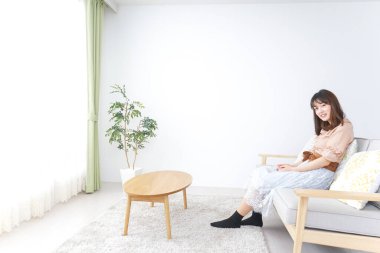 Genç bayan odada dinleniyor.