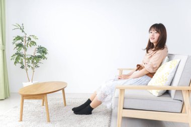 Genç bayan odada dinleniyor.