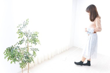 Genç bir kadın odasını temizliyor.