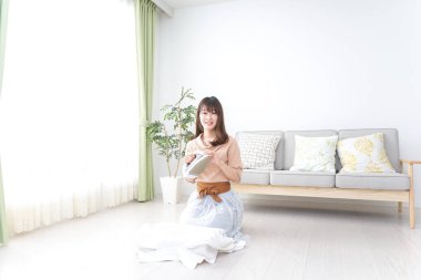 Elbiselerini ütüleyen genç kadın.