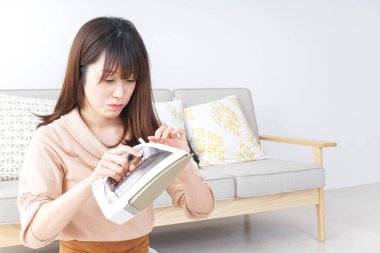 Elbiselerini ütüleyen genç kadın.