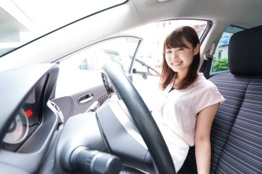 Arabayla dışarı çıkan genç bir kadın.