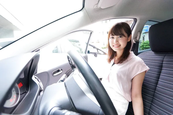 Arabayla dışarı çıkan genç bir kadın.