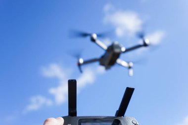 Mavi gökyüzü arka planında bir İHA 'yı kontrol etmek