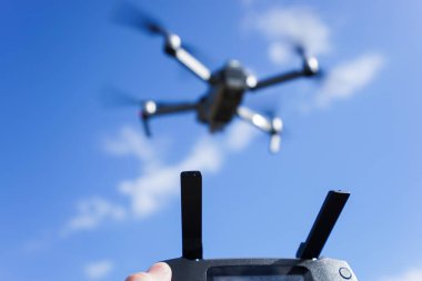 Mavi gökyüzü arka planında bir İHA 'yı kontrol etmek