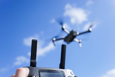 Mavi gökyüzü arka planında bir İHA 'yı kontrol etmek