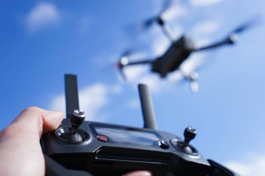 Mavi gökyüzü arka planında bir İHA 'yı kontrol etmek