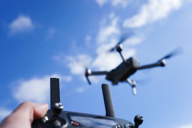 Mavi gökyüzü arka planında bir İHA 'yı kontrol etmek