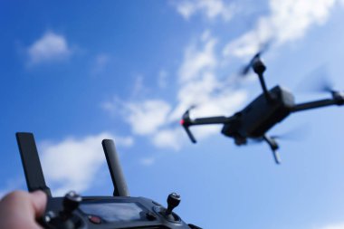 Mavi gökyüzü arka planında bir İHA 'yı kontrol etmek