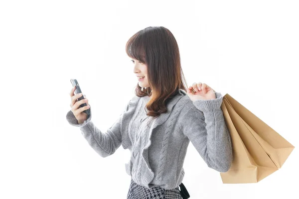 网上购物概念 带着智能手机和手工操作购物袋的女人 — 图库照片