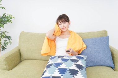 Evde televizyon izleyen bir kadın.