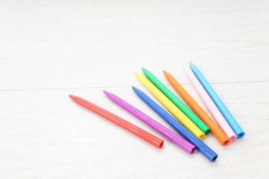 Beyaz arkaplanda renkli boya kalemleri