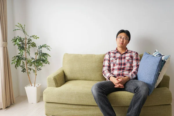 Glücklich Asiatische Mann Sitzt Auf Sofa Hause Stockfoto
