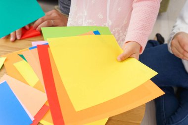 Çocuk origami kağıdını katlıyor