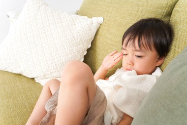 Çocuk kanepede uyuyor.