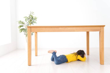 Masanın altına kıvrılmış çocuk