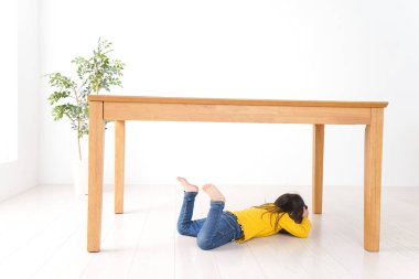 Masanın altına kıvrılmış çocuk