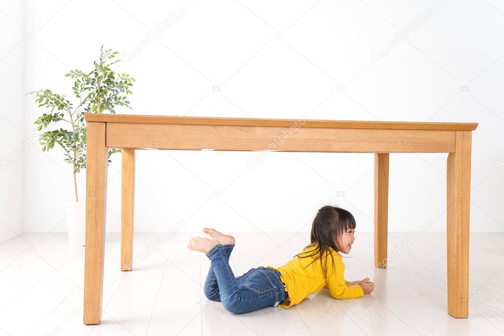 Child huddling under a table