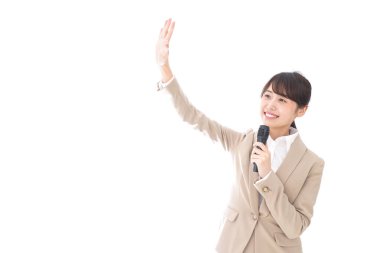 Kadın mikrofonla konuşuyor.  