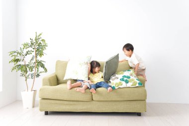 Gülümseyen çocuk odada oynuyor.