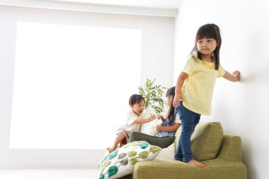 Gülümseyen çocuk odada oynuyor.