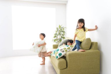 Gülümseyen çocuk odada oynuyor.