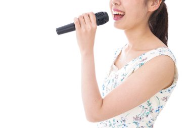 Genç kadın beyazda karaoke yapıyor. 