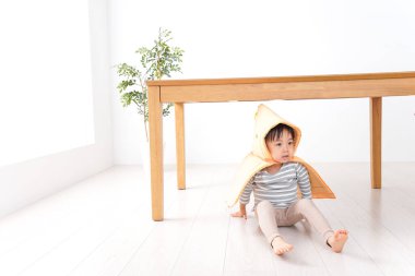 Odada başını koruyan bir çocuk var.