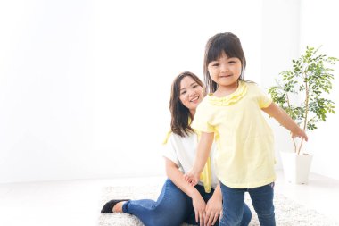 Anne çocuğuyla oynuyor, anne ve kızı birlikte vakit geçiriyorlar.